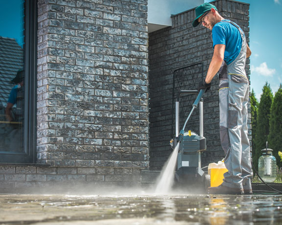 This image shows a man power spraying the floor.