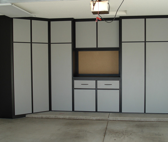 This image shows a garage floor with flake epoxy painted floor. There are cabinets on the wall.