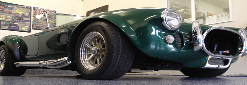 This image shows a flake epoxy floor. A green classic car is parked there.