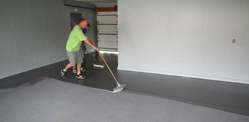This image shows 2 men painting an industrial floor.