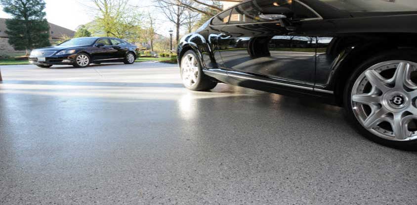 This image shows an epoxy floor. A black car is parked there.