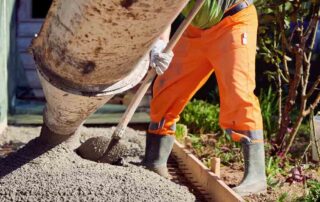 This image shows a man using a shovel to prepare a cement.